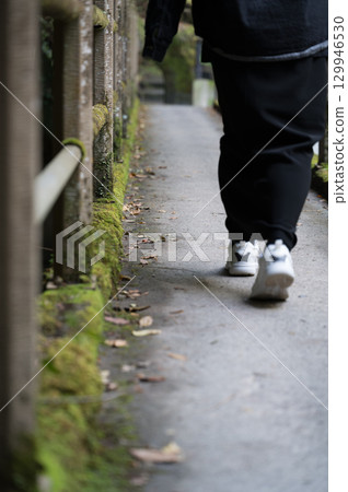 一個人沿著山谷長廊行走的腳 129946530