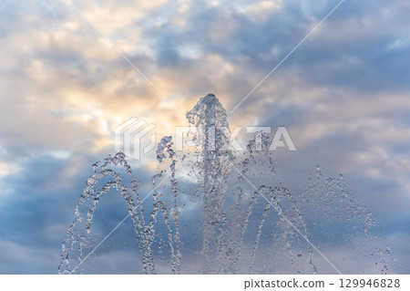 Splashes and jets of water against light background. 129946828