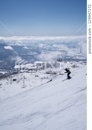 Skiers skiing down the dynamic course at Niseko Tokyu Grand Hirafu 129947272