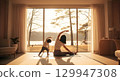 Mother and young child practicing yoga and stretching together in a bright 129947308