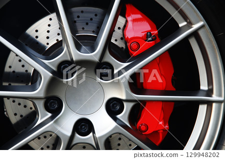Sports car wheel and red brake caliper Sports car wheel and red brake caliper 129948202