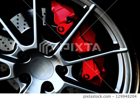 Sports car wheel and red brake caliper 129948204