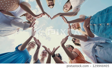 School friends joining hands to create a star shape, representing teamwork and solidarity School friends joining hands to create a star shape, representing teamwork and solidarity 129948405