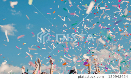 Graduating students gleefully tossing colorful confetti to mark their achievement and embrace new beginnings 129948434