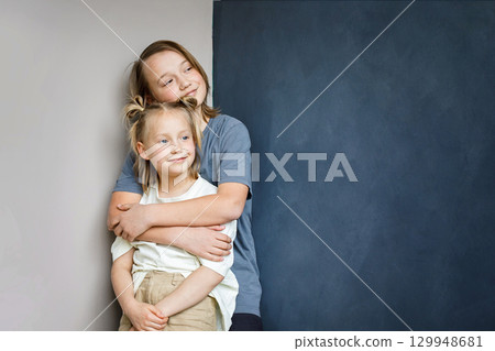 Cute young sister and brother hugging indoor. Sibling children together portrait 129948681