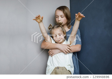 Playful young sister and brother having fun and hugging indoor. Sibling children together portrait 129948696