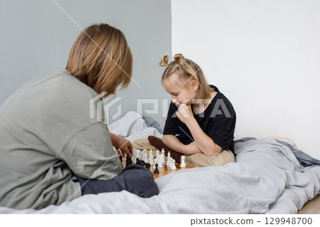 Concentrated boy and girl playing chess board game while thinking of move with knowledge 129948700