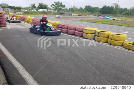 Man go-karting on a motor racing track 129948940