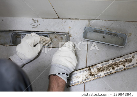 Dirty messy sewer hole, bathroom drain and worker hands Dirty messy sewer hole, bathroom drain and worker hands 129948943