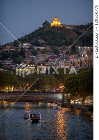 Tourist cruise boats sightseeing tours along Mtkvari Kura river in central Tbilisi, capital of Georgia 129950770