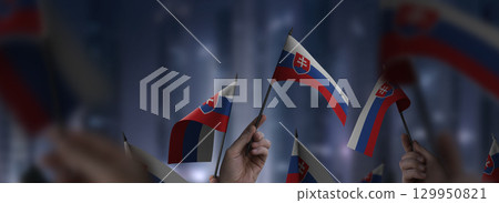 Slovakia flags in their hands on a blurred urban background 129950821