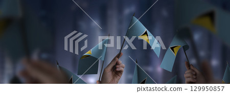 Saint Lucia flags in their hands on a blurred urban background 129950857