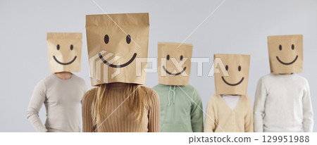 Group of unidentified people carry paper bags with smiley emoticons painted on heads. Group of unidentified people carry paper bags with smiley emoticons painted on heads. 129951988