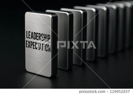 A row of black domino like blocks each engraved with leadership expectation symbolizing consistency and structured leadership 129952837