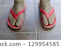 Funny fashion fail with socks and flip flops on tiles 129954585