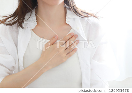 Woman with hand on chest worried Woman with hand on chest worried 129955478