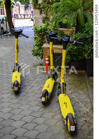 Yellow Yandex electric scooters parked in a city street in Tbilisi, Georgia Yellow Yandex electric scooters parked in a city street in Tbilisi, Georgia 129955484