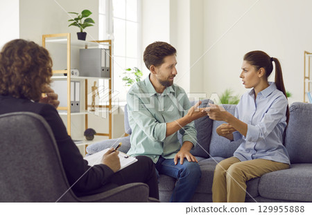 Young couple blaming each other in marriage problems sitting at family therapist office. Young couple blaming each other in marriage problems sitting at family therapist office. 129955888