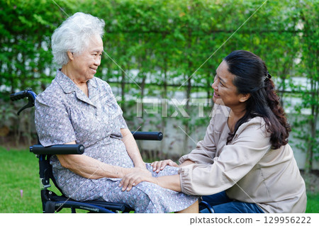 Caregiver help Asian elderly woman disability patient sitting on wheelchair in park, medical. Caregiver help Asian elderly woman disability patient sitting on wheelchair in park, medical. 129956222