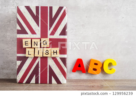 English book with graduate hat, learning and tutorial for foreigner. 129956239