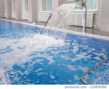 Whirlpool installation in an indoor pool, close-up, for relaxing and massaging the neck and back 129956998