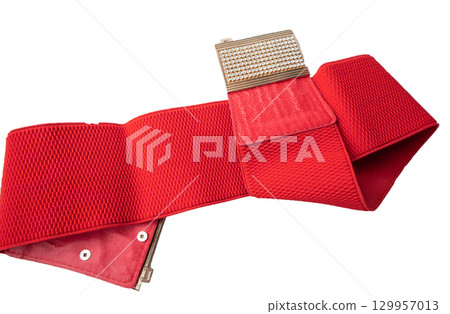 Red fashionable women's knitted elastic band belt with metal buckle with rhinestones, isolated on white background 129957013