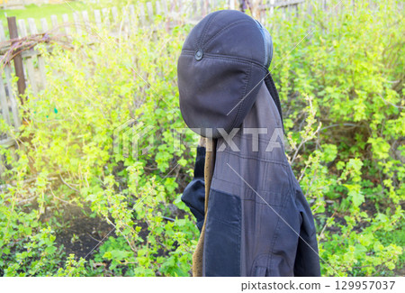 Men's work clothes hanging in the garden coat and hat 129957037