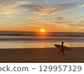 Beautiful beach sunset and surfer Beautiful beach sunset and surfer 129957329