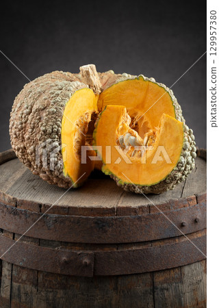 Sliced Buen Gusto de Horno Pumpkin on Old Wooden Barrel 129957380