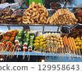 Colorful display of Thai street food with skewers, fried shrimp and spring rolls. Concept of culture, variety, community, tradition, flavor and lifestyle. 129958643