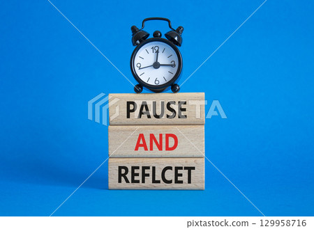 Pause and Reflect symbol. Concept words Pause and Reflect on wooden blocks. Beautiful blue background with alarm clock. Business and Pause and Reflect concept. Copy space. 129958716