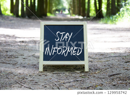 Stay Informed symbol. Concept word Stay Informed on chalk blackboard. Beautiful forest background. Business and Stay Informed concept. Copy space. 129958742
