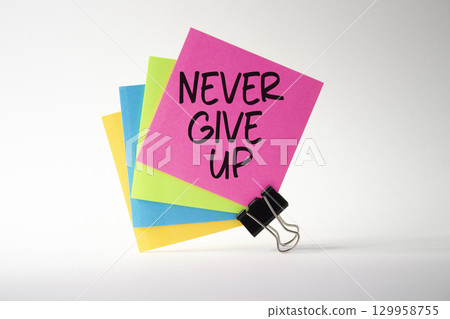 Never give up symbol. Sticky notes with Concept words Never give up. Beautiful white background. Business and Never give up concept. Copy space. 129958755