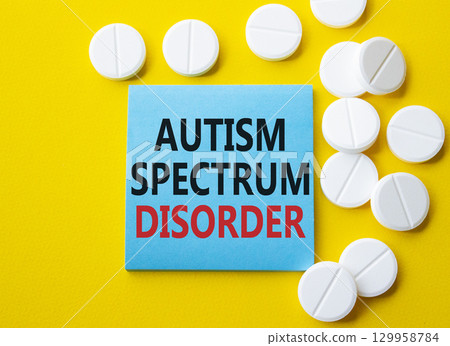 Autism Spectrum Disorder symbol. Concept word Autism Spectrum Disorder on blue note. Beautiful yellow background with pills. Medicine and Autism Spectrum Disorder concept. Copy space Autism Spectrum Disorder symbol. Concept word Autism Spectrum Disorder on blue note. Beautiful yellow background with pills. Medicine and Autism Spectrum Disorder concept. Copy space 129958784