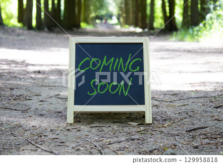 Coming Soon symbol. Concept word Coming Soon on chalk blackboard. Beautiful forest background. Business and Coming Soon concept. Copy space. Coming Soon symbol. Concept word Coming Soon on chalk blackboard. Beautiful forest background. Business and Coming Soon concept. Copy space. 129958818