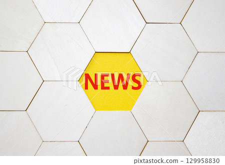News symbol. Concept word News on wooden comb puzzle. Beautiful yellow background. Business and News concept. Copy space. 129958830