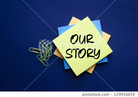 Our story symbol. Yellow sticky notes with words Our Story. Beautiful deep blue background. Business and Our story concept. Copy space. 129958839