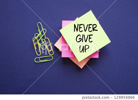Never give up symbol. Sticky notes with Concept words Never give up. Beautiful deep blue background. Business and Never give up concept. Copy space. 129958866