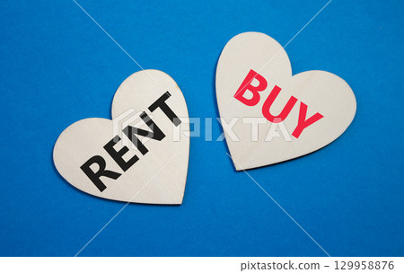 Rent or Buy symbol. Concept word Rent or Buy on wooden hearts. Beautiful blue background. Business and Rent or Buy concept. Copy space 129958876