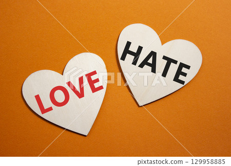 Love vs Hate symbol. Concept word Love vs Hate on wooden hearts. Beautiful orange background. Business and Love vs Hate concept. Copy space 129958885