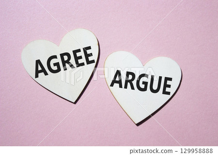 Agree or Argue symbol. Concept word Agree or Argue on wooden hearts. Beautiful pink background. Business and Agree or Argue concept. Copy space Agree or Argue symbol. Concept word Agree or Argue on wooden hearts. Beautiful pink background. Business and Agree or Argue concept. Copy space 129958888
