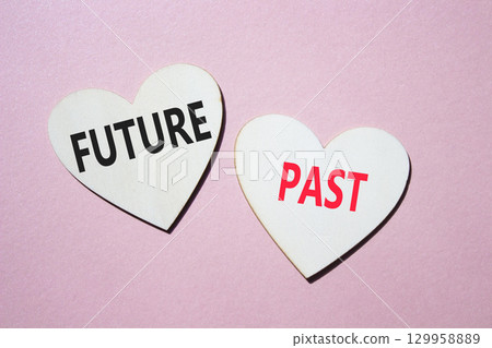 Future or Past symbol. Concept word Future or Past on wooden hearts. Beautiful pink background. Business and Future or Past concept. Copy space Future or Past symbol. Concept word Future or Past on wooden hearts. Beautiful pink background. Business and Future or Past concept. Copy space 129958889