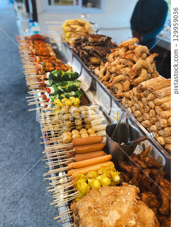 Thai street food stall with assorted grilled meat, vegetables, spring rolls and sausages. Concept of culture, tradition, lifestyle and authentic cuisine. Thai street food stall with assorted grilled meat, vegetables, spring rolls and sausages. Concept of culture, tradition, lifestyle and authentic cuisine. 129959036