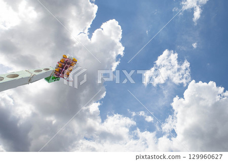 Fairground attraction and cloudy sky Fairground attraction and cloudy sky 129960627