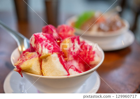 Namkhaeng Sai or Wan Yen, a Thai shaved ice in a bowl with bread, topped with sweet syrup and condensed milk. Namkhaeng Sai or Wan Yen, a Thai shaved ice in a bowl with bread, topped with sweet syrup and condensed milk. 129960717
