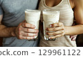 Couple holding glasses of milk 129961122