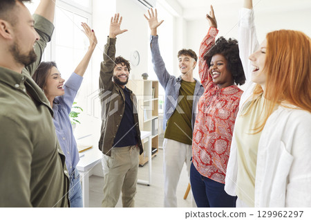 Multinational Business Team Celebrating Success With Raised Hands In The Office Multinational Business Team Celebrating Success With Raised Hands In The Office 129962297