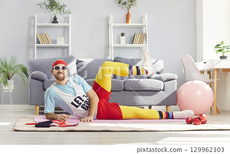 Funny happy sportsman relaxing pose doing body rest on floor, sitting to exercise, playful fitness 129962303