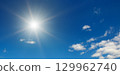 Sun on beautiful blue sky with white clouds. 129962740