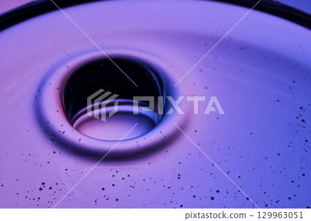Beautiful texture of cosmetic oil on a purple background. 129963051